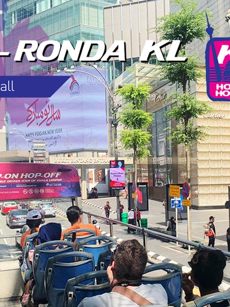 Open-top bus on Kuala Lumpur street for Hop On Hop Off tour near Sunway Lagoon.