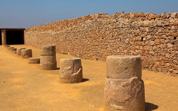 Ancient stone columns and wall at the Ruins of Empúries, Spain.