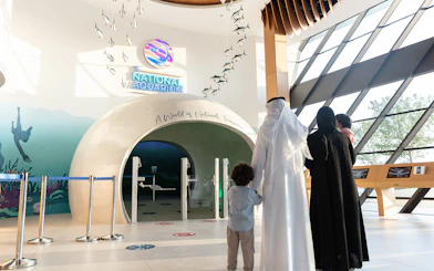 Entrance to National Aquarium Abu Dhabi with family preparing for Bu Tinah Dhow Experience.
