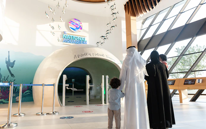 Entrance to National Aquarium Abu Dhabi with family preparing for Bu Tinah Dhow Experience.