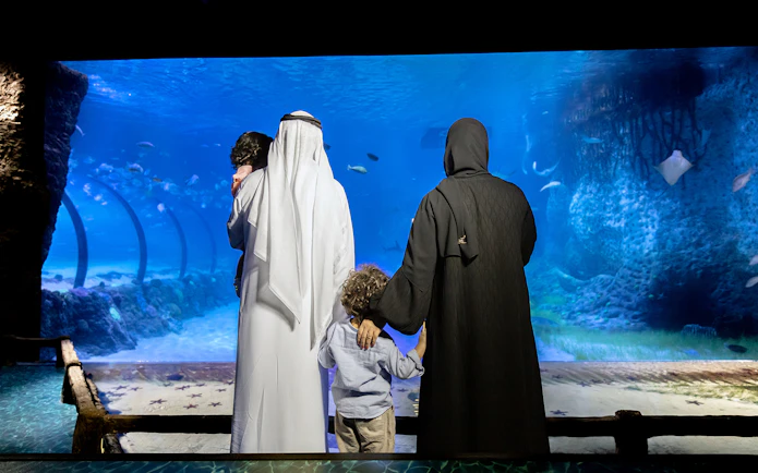 Family viewing marine life at National Aquarium Abu Dhabi.