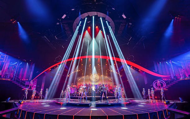 Performers on stage with vibrant lights at ARISE Grand Show.