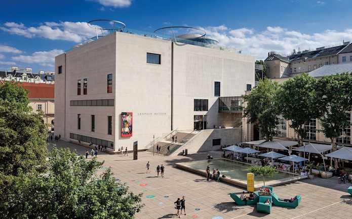 Tourists with tickets exploring the Leopold Museum courtyard in Vienna.