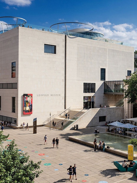 Tourists with tickets exploring the Leopold Museum courtyard in Vienna.