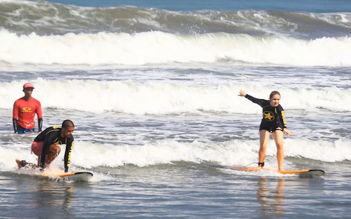 Surf lesson participants riding waves at Odysseys Surf School.