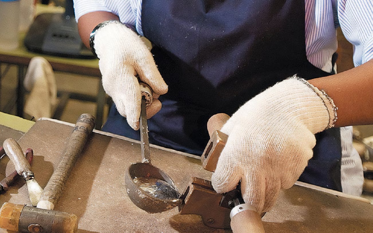 Craftsman working with metal tools during Kuala Lumpur countryside tour.