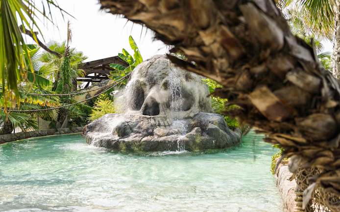Skull-shaped rock waterfall at Caribe Bay water park entrance.
