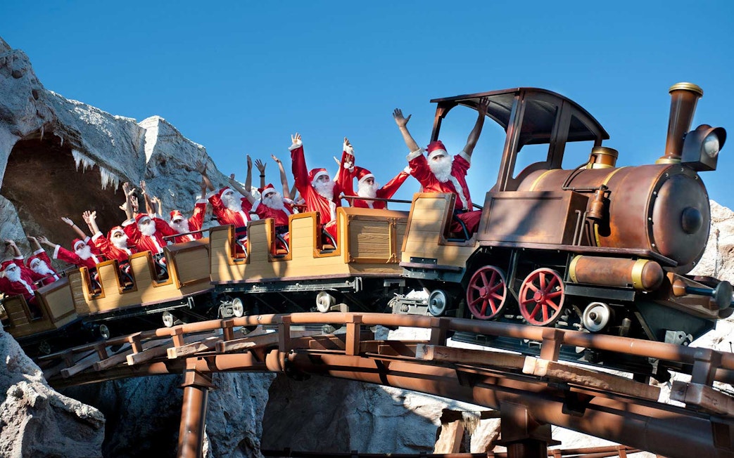 People dressed as Santa Claus on a roller coaster at Gardaland Park.
