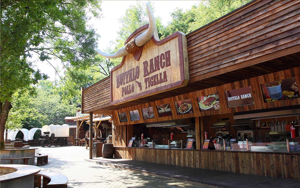 Buffalo Ranch food stand at Gardaland Park with covered wagons nearby.