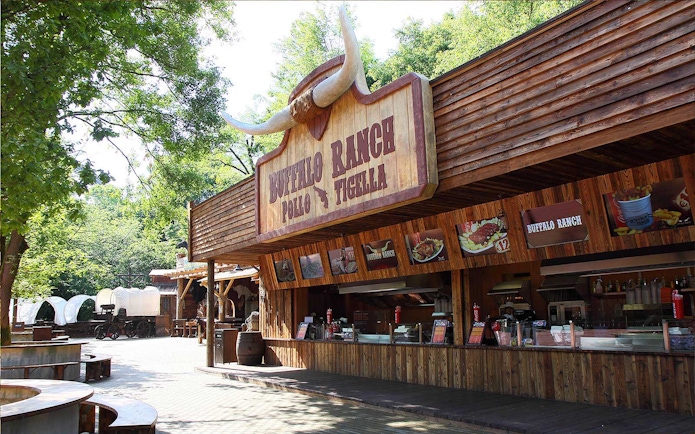 Buffalo Ranch food stand at Gardaland Park with covered wagons nearby.