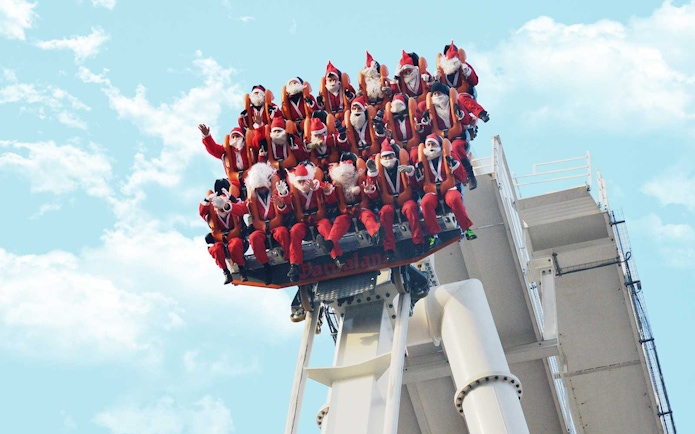 Visitors dressed as Santa Claus on a ride at Gardaland Park, Italy.