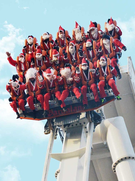 Visitors dressed as Santa Claus on a ride at Gardaland Park, Italy.