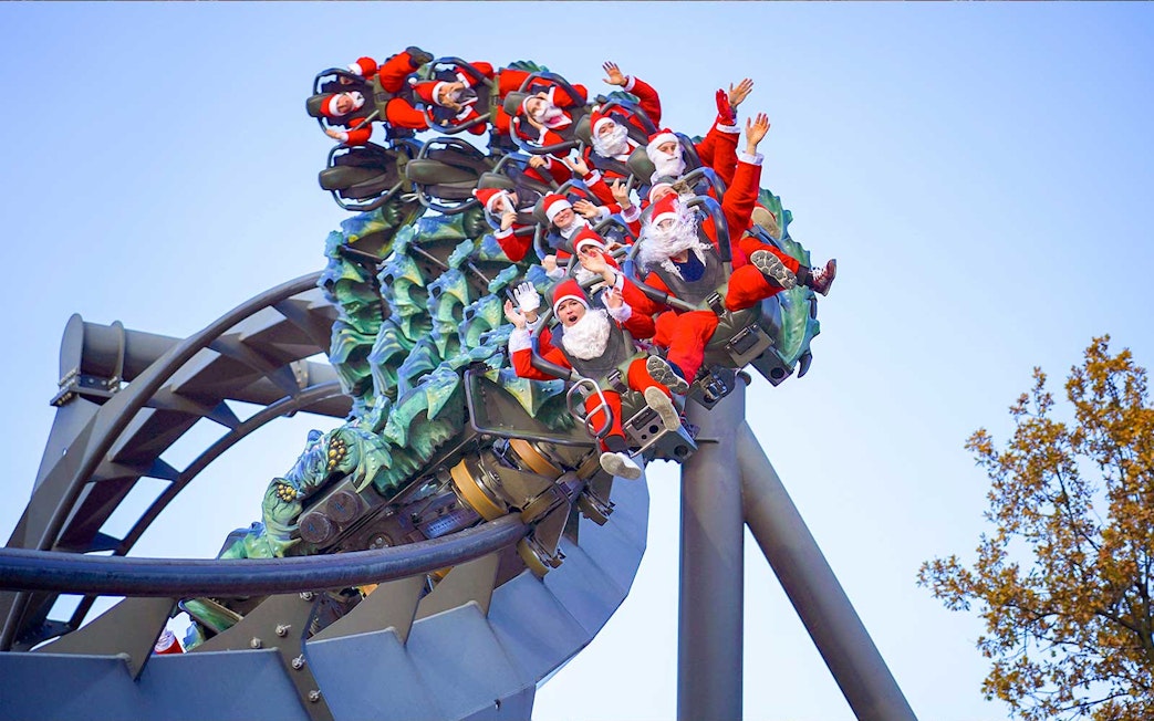 Roller coaster with people in Santa costumes at Gardaland Park, Italy.