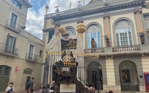 Facade of the Dali Museum in Figueres with unique sculptures and visitors.