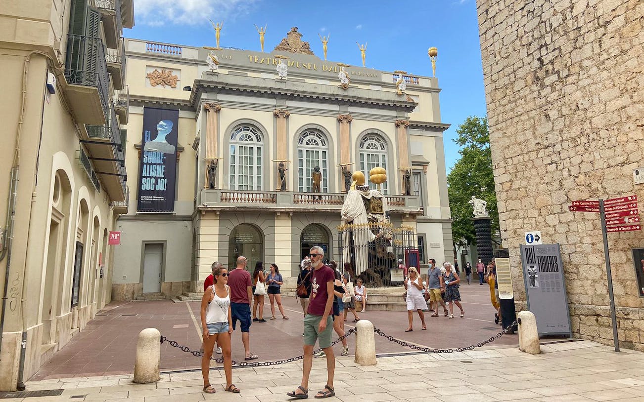Dalí Theatre-Museum entrance in Figueres with visitors exploring the courtyard.