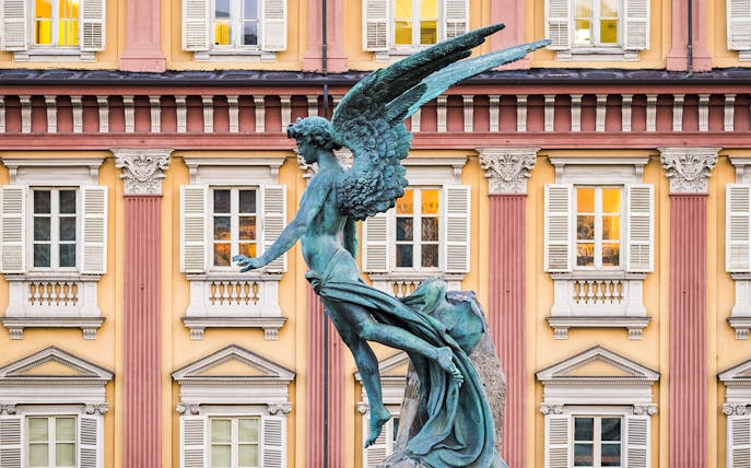 Statue of an angel in front of a historic building on the Torino Magica tour.