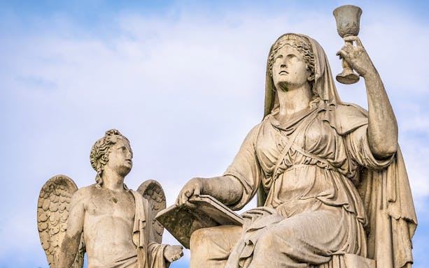 Statues of an angel and a woman with a chalice on the Torino Magica tour.