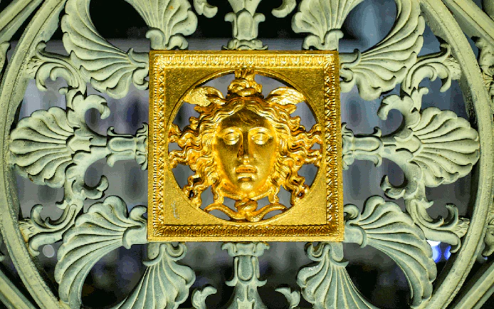 Golden Medusa emblem on ornate gate during Torino Magica tour.