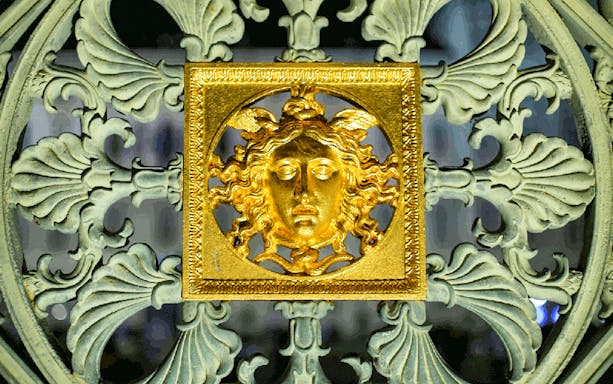 Golden Medusa emblem on ornate gate during Torino Magica tour.