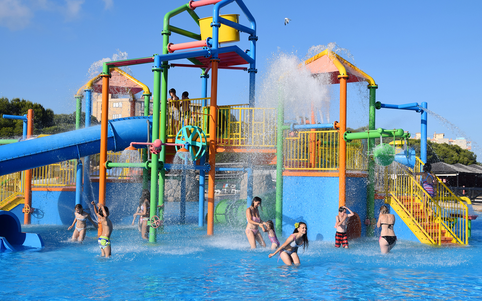 Children playing in water park at Aquopolis Costa Daurada with colorful slides and splash features.