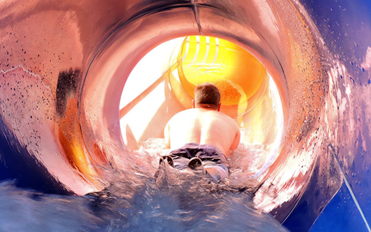 Person sliding down a water slide at Aquopolis Torrevieja.