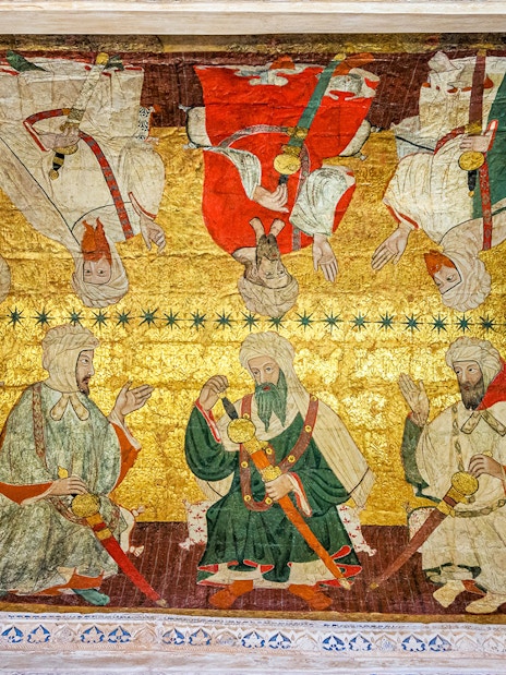 Alhambra ceiling artwork depicting historical figures in traditional attire.