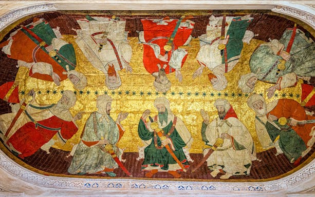 Alhambra ceiling artwork depicting historical figures in traditional attire.