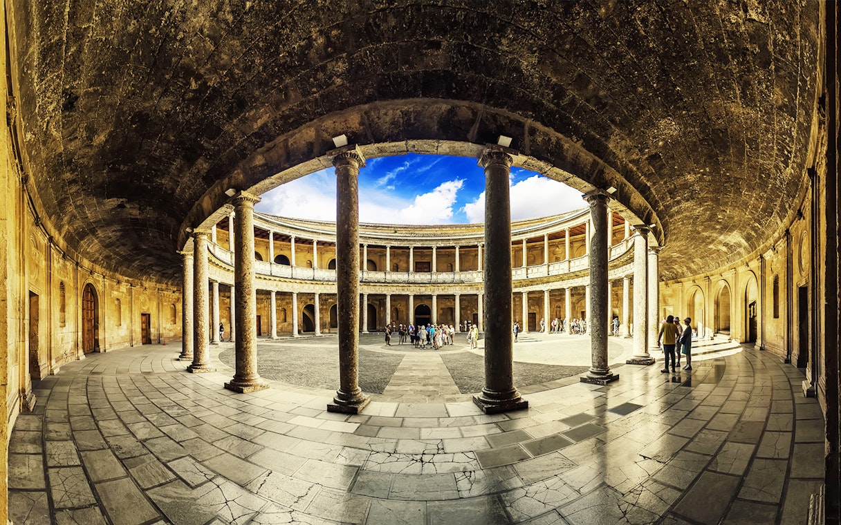 Alhambra's circular courtyard with tourists exploring, Granada, Spain.