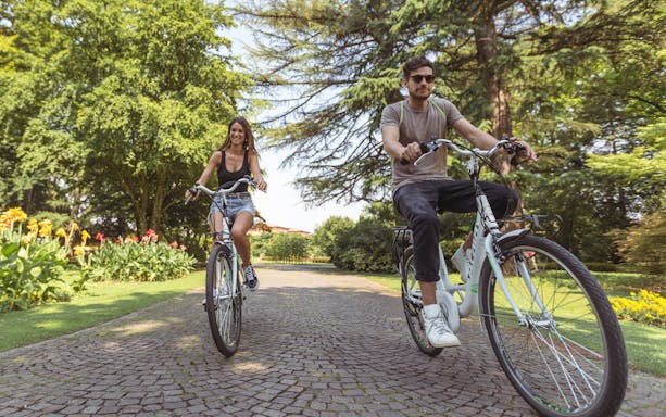 Cyclists enjoying a ride through Parco Giardino Sigurtà's scenic paths.