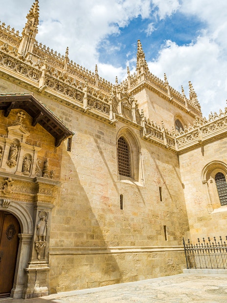 Cathedral and Royal Chapel of Granada exterior with ornate stone carvings and Gothic architecture.