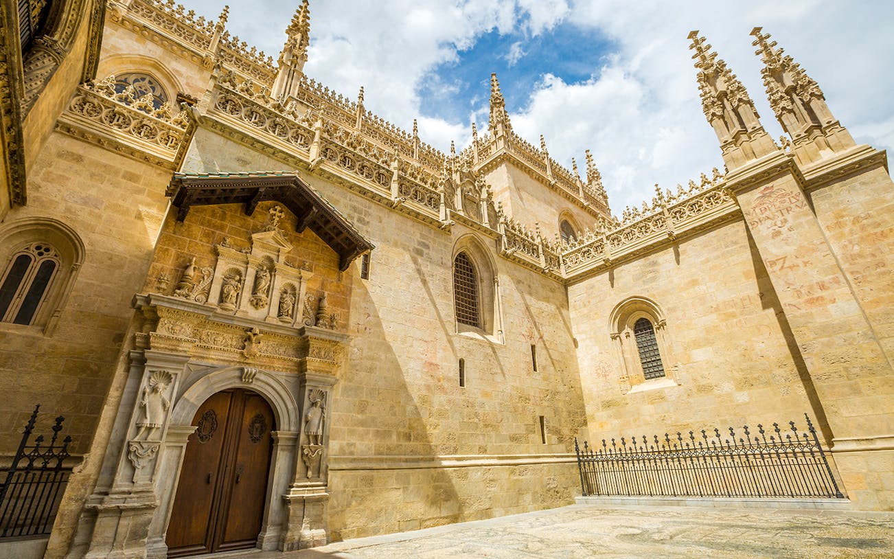 Cathedral and Royal Chapel of Granada exterior with ornate stone carvings and Gothic architecture.