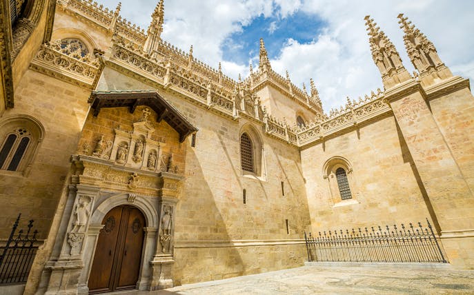 Cathedral and Royal Chapel of Granada exterior with ornate stone carvings and Gothic architecture.