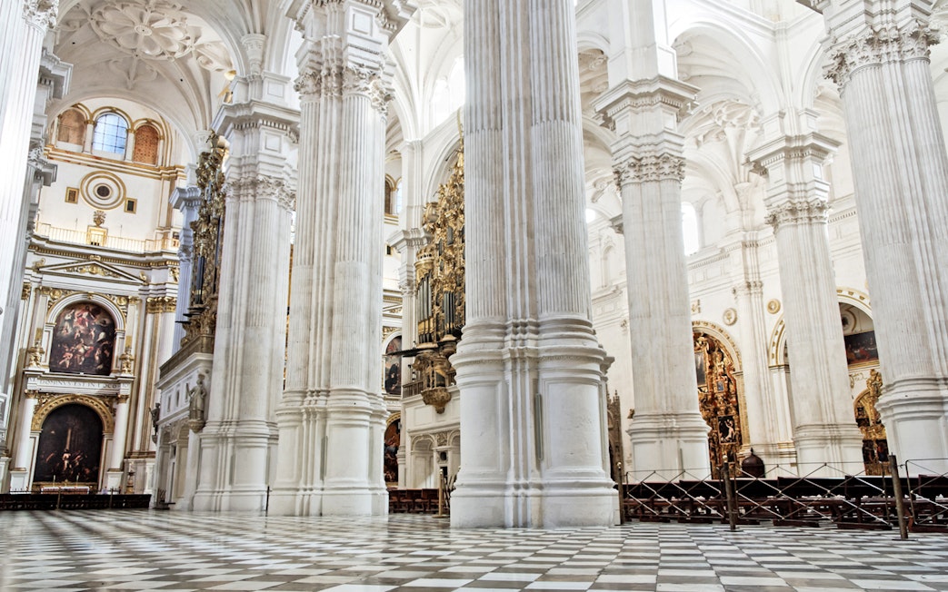 Interior of Cathedral and Royal Chapel of Granada with ornate columns and arches.