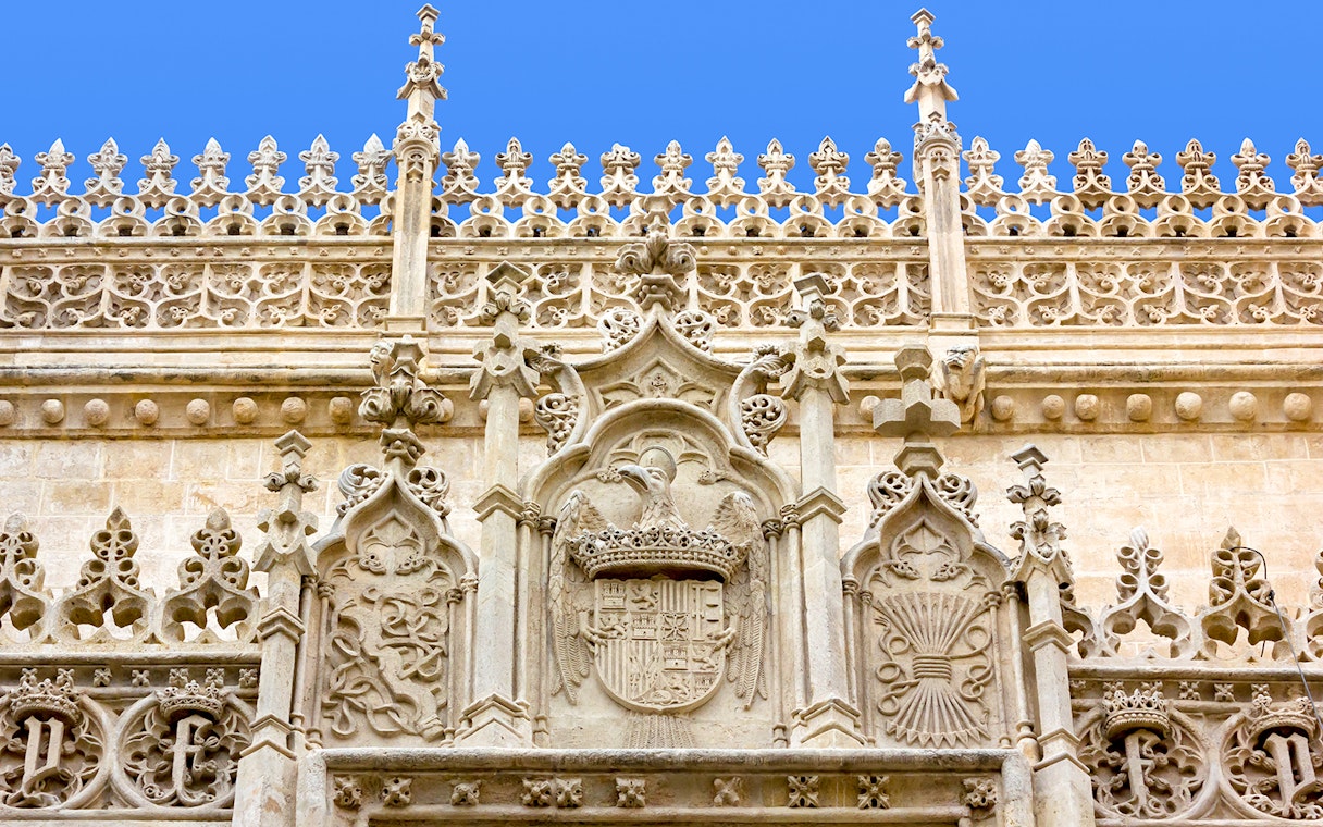 Ornate stone facade of the Cathedral and Royal Chapel of Granada, featuring intricate Gothic carvings.