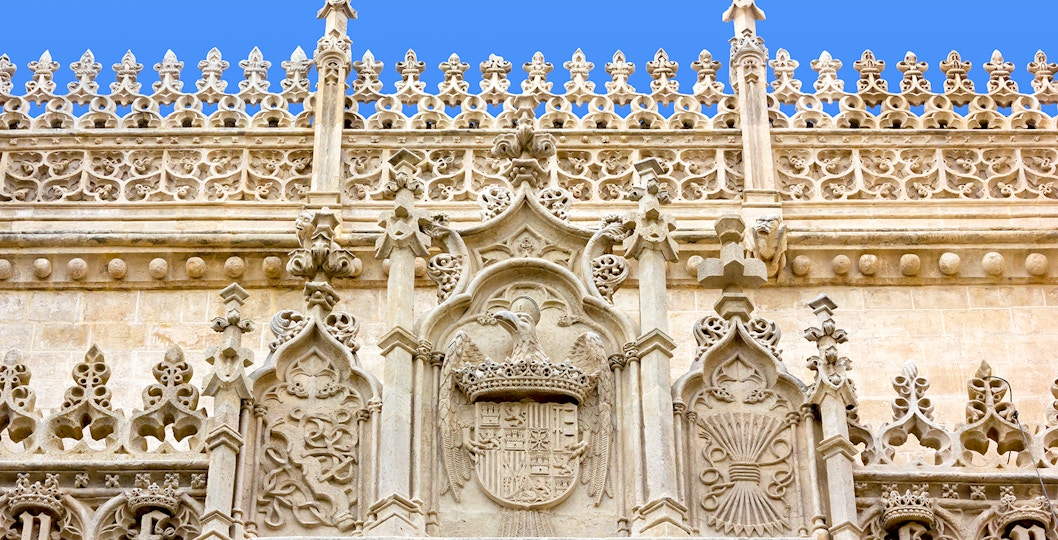 Ornate stone facade of the Cathedral and Royal Chapel of Granada, featuring intricate Gothic carvings.