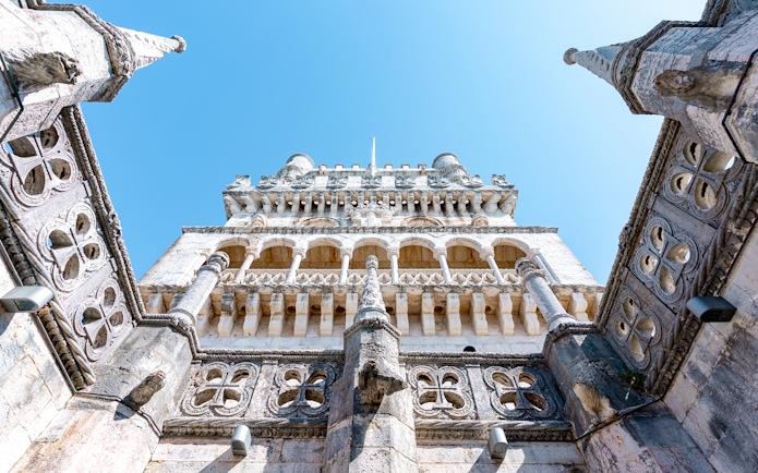 Belém Tower's ornate stone facade and turrets against a clear sky in Lisbon, Portugal.
