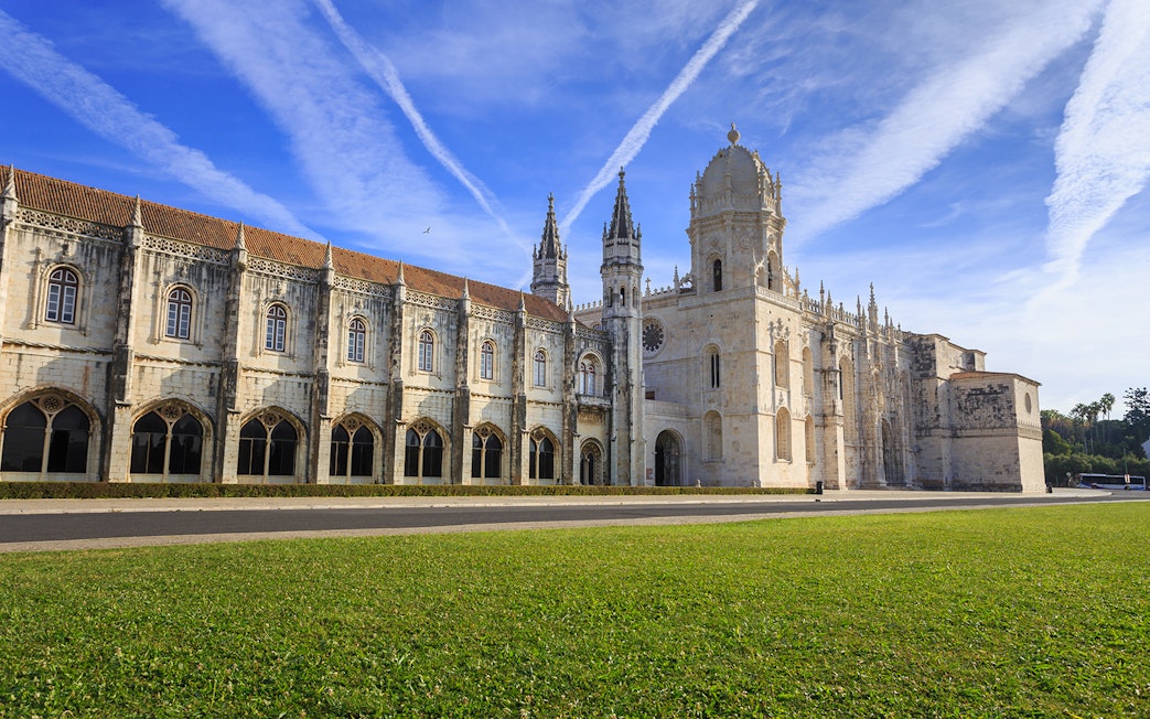 Jerónimos Monastery facade in Lisbon under a clear blue sky.