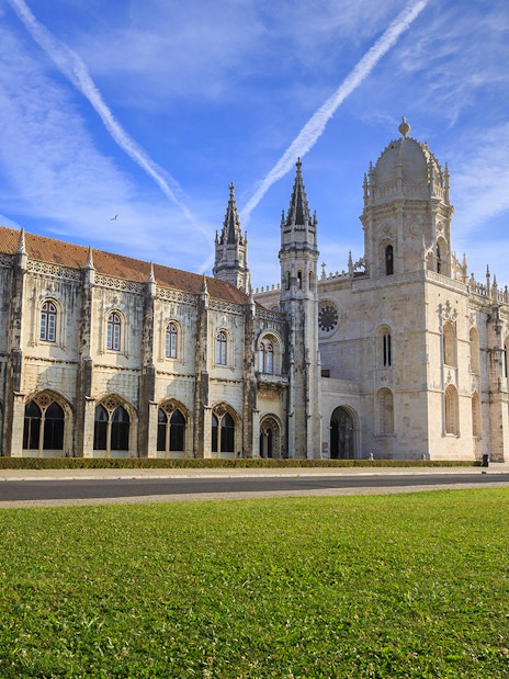 Jerónimos Monastery facade in Lisbon under a clear blue sky.