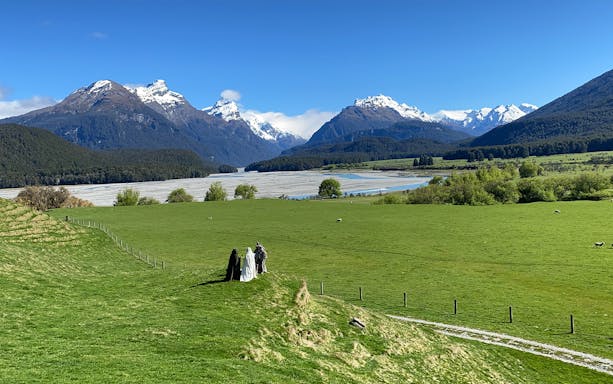 Scenic view of snow-capped mountains and green fields on Lord of the Rings tour from Queenstown.
