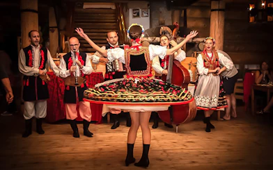 Polish folk dancers and musicians performing at a traditional dinner event.