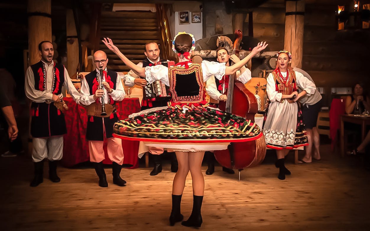 Polish folk dancers and musicians performing at a traditional dinner event.