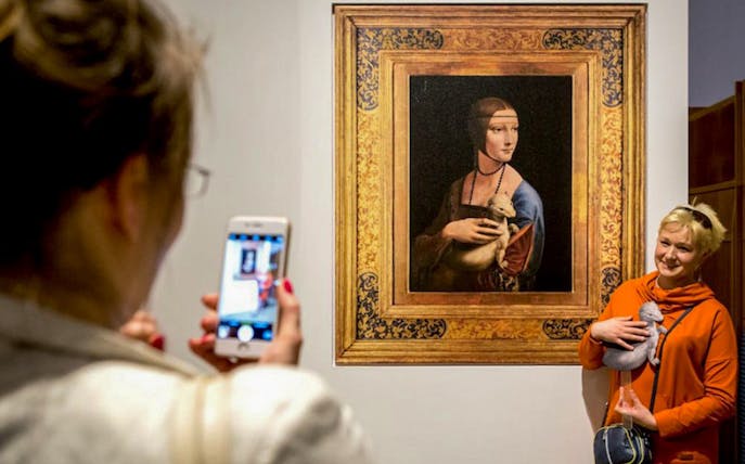 Visitor photographing "Lady with an Ermine" at Czartoryski Museum during English guided tour.