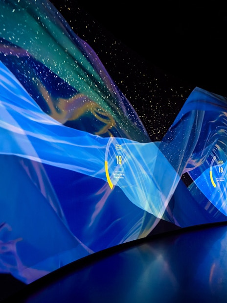 Silhouette of a person viewing digital art display at Torre Glories Lookout, Barcelona.