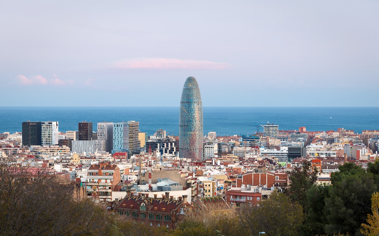 Torre Glòries in Barcelona skyline with Mediterranean Sea in the background.