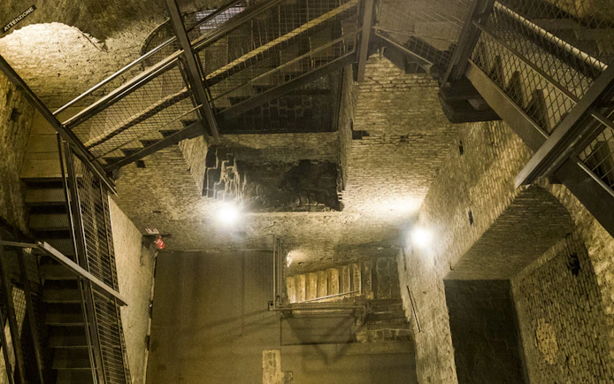 Underground passage with brick walls and metal stairs on the Italian Guided Tour through Torino Noir.