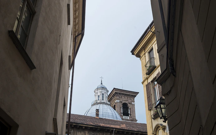 Historic buildings and dome in a narrow alley, Torino Noir tour, Italy.