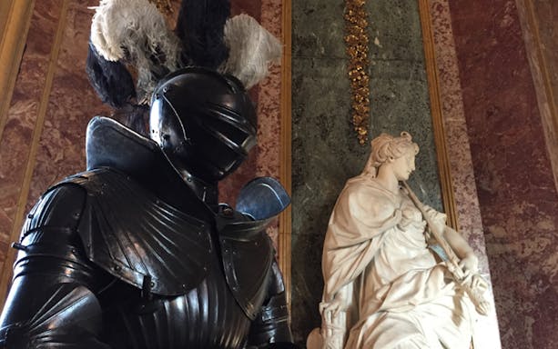 Knight armor and marble statue inside the Royal Palace of Turin.