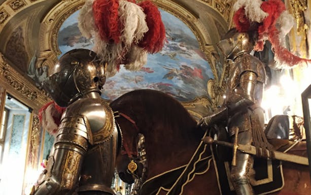 Armored knights on horseback inside the Royal Palace of Turin.