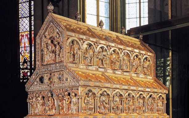 Golden shrine with intricate carvings inside Cologne Cathedral.