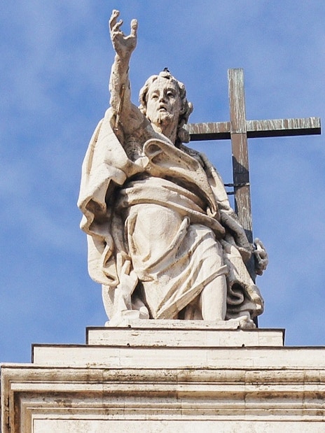 Statue atop St. John Lateran Basilica in Rome holding a cross.